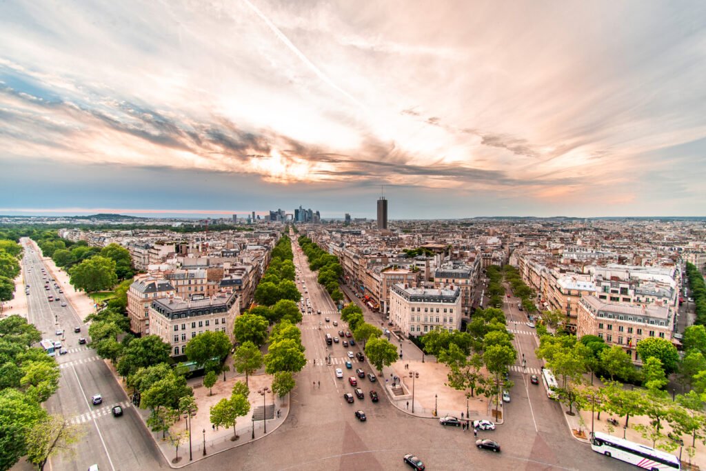 A romantic view of Paris featuring the Eiffel Tower glowing at dusk, the Seine River reflecting the city lights, and classic Parisian architecture surrounding the scene.