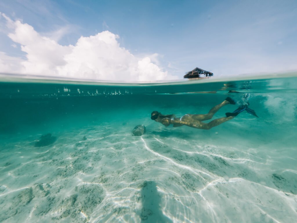 young blonde snorkeling and looking at camera