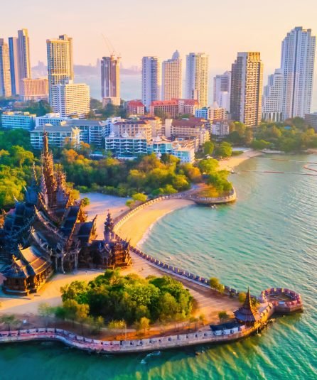 sanctuary of truth, pattaya, thailand, wooden temple by the ocean at sunset on the beach of pattaya